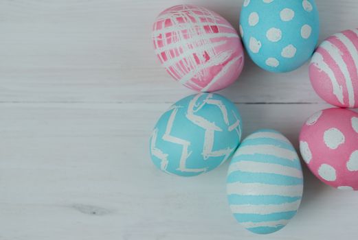 Pink and blue easter eggs on a wooden background