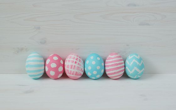 Pink and blue easter eggs on a wooden background