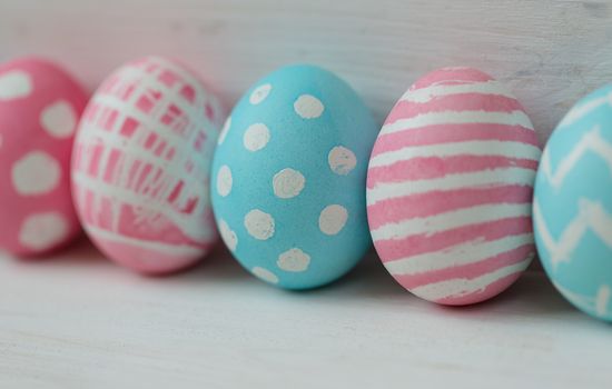 Pink and blue easter eggs on a wooden background