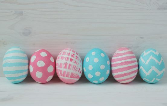 Pink and blue easter eggs on a wooden background