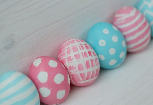 Pink and blue easter eggs on a wooden background