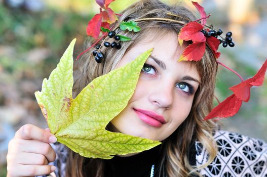 pretty girl wearing autumn crown holding leaf