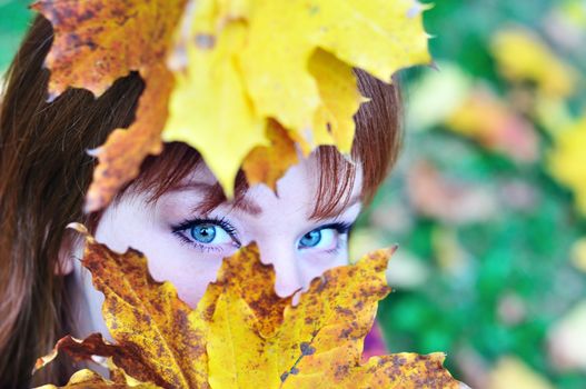 autumn view of redheaded girl in forest