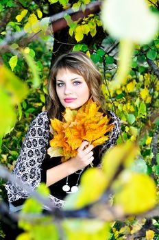 beautiful teen girl sitting in the autumn forest