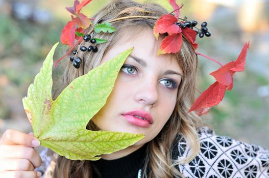 face of tender girl wearing autumn crown 