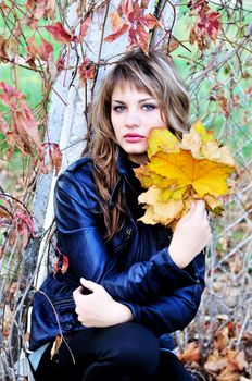 teen tender girl wearing leather jacket in the autumn park