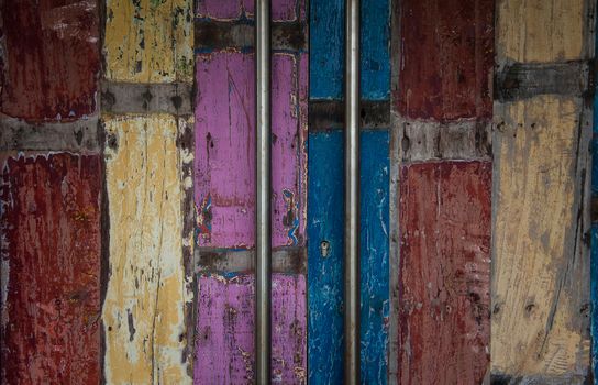 Aged doors, of a bar in Bali, indonesia. Long metal handles, and aged colored wooden door.