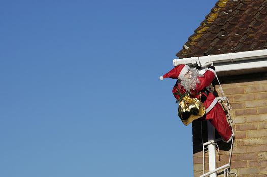 mannequin santa climbing a ladder in daylight to deliver presents
