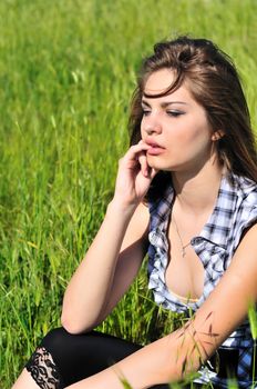 spring beautiful teen girl sitting  on the meadow 