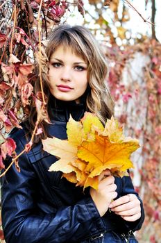 beautiful teen girl stending in the autumn park 