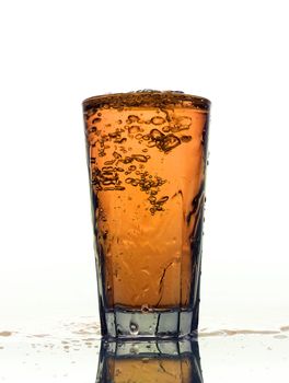 Glass of splashing Orange lemonade isolated on white background
