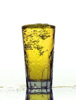 Glass of splashing Yellow lemonade isolated on white background