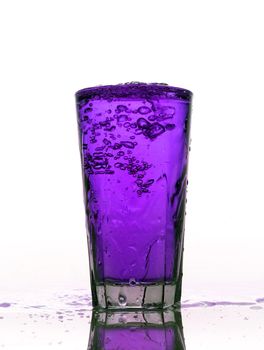 Glass of splashing Purple lemonade isolated on white background
