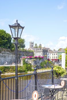 beautiful antique street lamp and riverside view of kilkenny castle in ireland