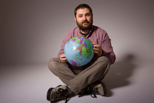 young casual man full body with a globe