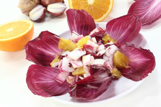 fresh red chicory salad with orange slices and dressing