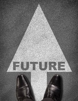 Top view of shoes standing on asphalt road with arrow and word future. Business concept