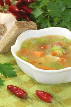 Poultry consomme soup with green, smooth parsley and bread