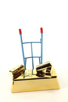 four gold bars on a hand truck on a light background