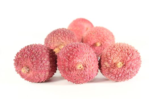 six fresh red lychees on a bright red background