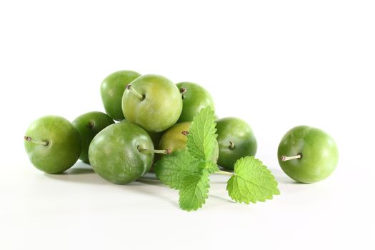 fresh green Mirabelle plums on a white background
