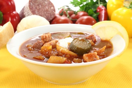 Soljanka in a soup bowl with pickles on a light background