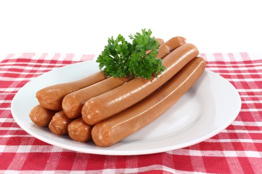 stacked Wiener sausages with parsley on a plate