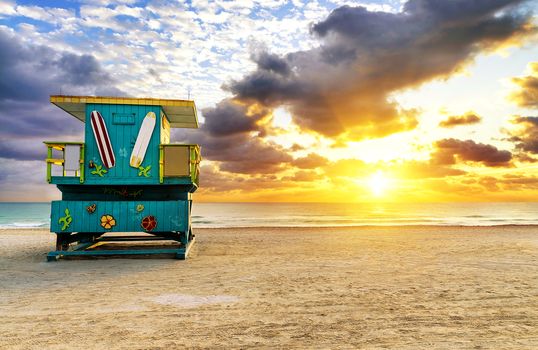 Miami South Beach sunrise with lifeguard tower and coastline with colorful cloud and blue sky. 