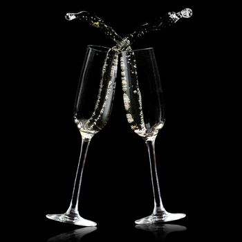 Two champagne glasses isolated on black with splashes