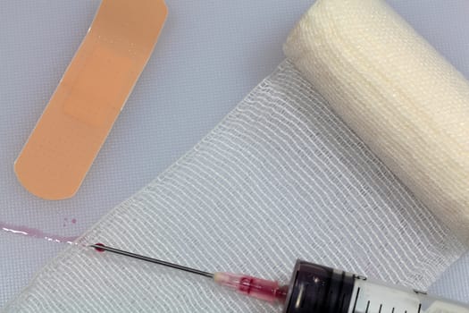 An injection needle with a bandage on a white background. 