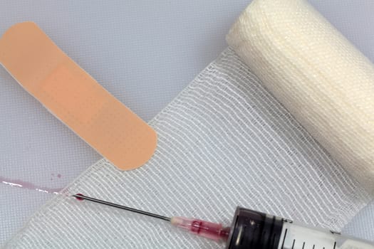 An injection needle with a bandage on a white background. 