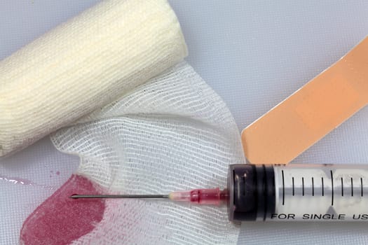 An injection needle with a bandage on a white background. 