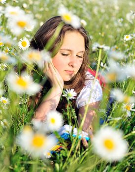 reading teen girl laying on the daisy meadow 