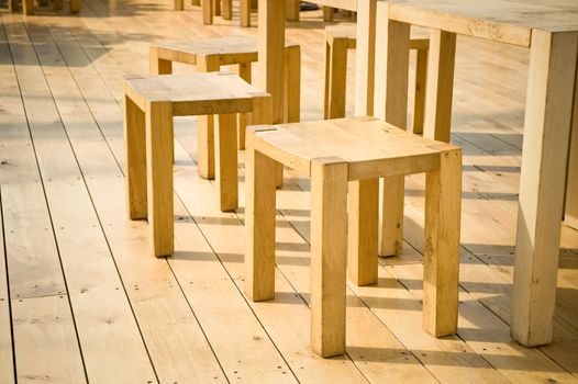 wooden stools and tables on decking floorboards