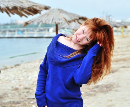 happy redheaded girl wearing blue sweater