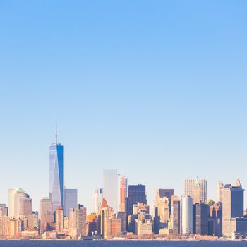 New York City Manhattan downtown skyline at sunset with skyscrapers illuminated over Hudson River panorama. Square composition, copy space.