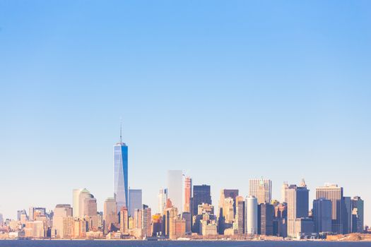 New York City Manhattan downtown skyline at sunset with skyscrapers illuminated over Hudson River panorama. Horisontal composition, copy space.