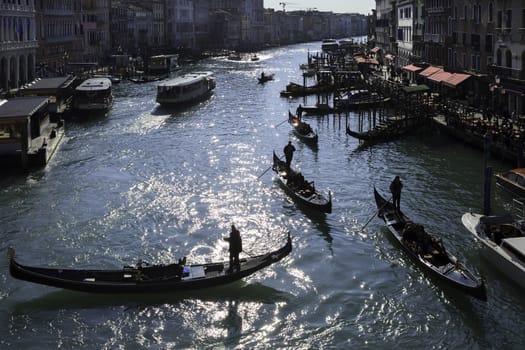 Many gondoliers bringing out tourists through the canals of Venice, Italy