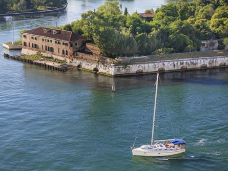 A beautiful white sailboat navigating close the canals of Venice, Italy