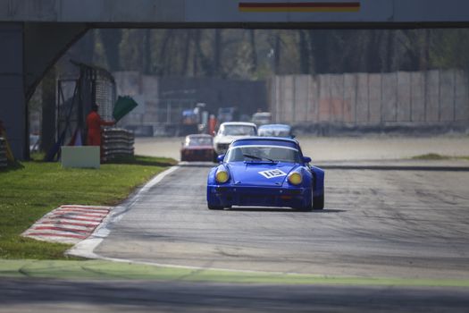 A red racing car running in the circuit of Monza, Italy