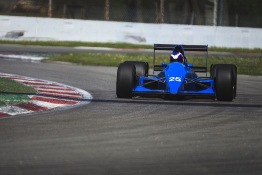 An old ligier racing car running in the circuit of Monza, Italy