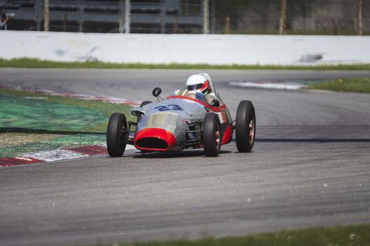 A red racing car running in the circuit of Monza, Italy