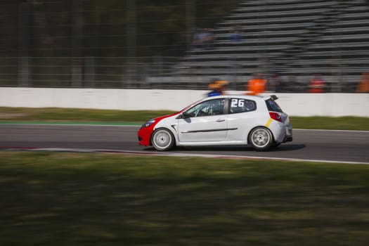 A little white racing car running in the circuit of Monza, Italy
