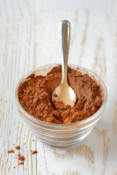  cocoa powder with a spoon on a wooden table