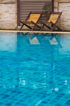 Chair on ground beside swimming pool day time with nobody