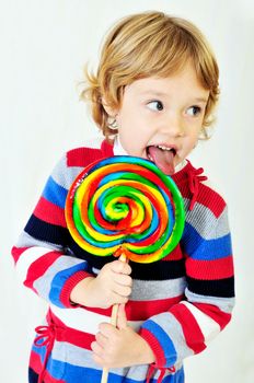 little girl licking big colorful lollipop