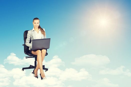 Beautiful businesswoman in suit sitting on office chair and holding open laptop, leaning back, smiling. Front view