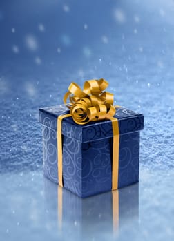 Blue present box on ice in realistic snowfall background