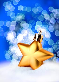 Golden Christmas decoration star on blue bokeh background