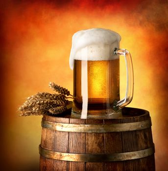 Glass of lager and wheat on a wooden barrel